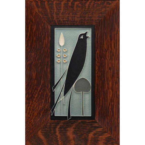 This image shows the light blue version of black songbird facing right. The tile is framed in a brown oak frame.